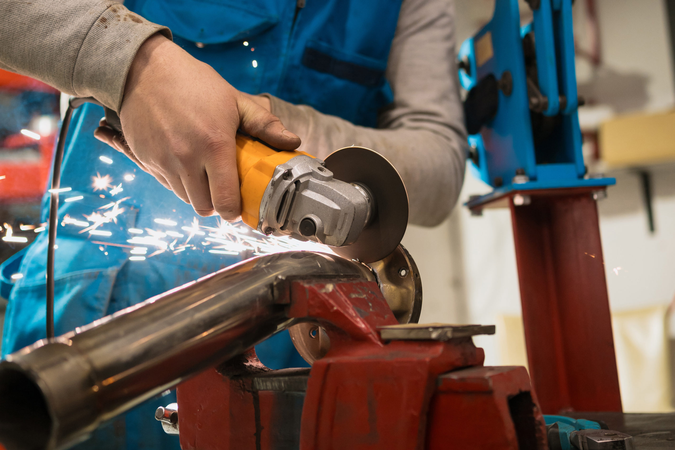 Technician worker cutting metal with many sharp sparks. Using equipments to cat iron